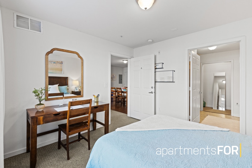 a bedroom with a desk and a mirror