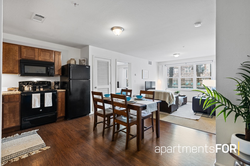 a room with a kitchen and dining table