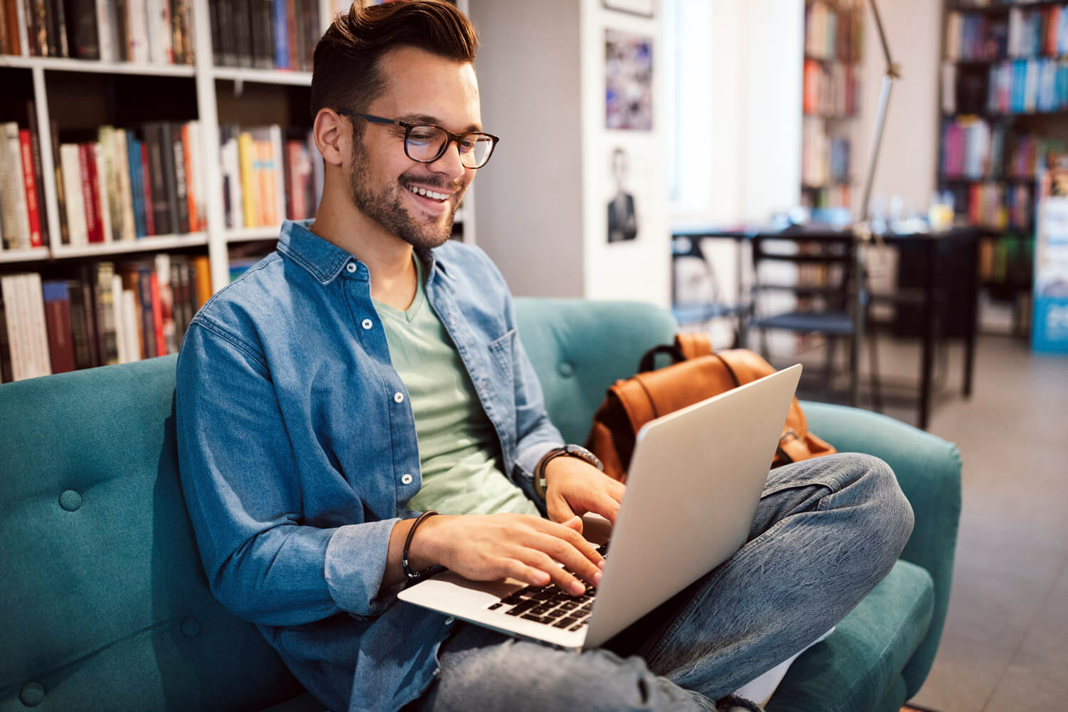 a man sitting on a chair using a laptop