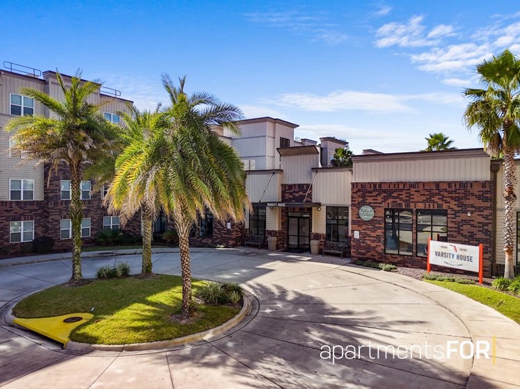 a building with palm trees and a parking lot