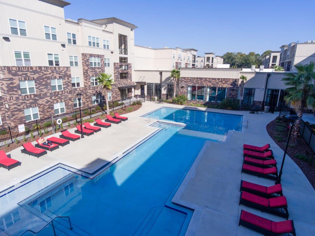 a pool and lounge chairs in a building