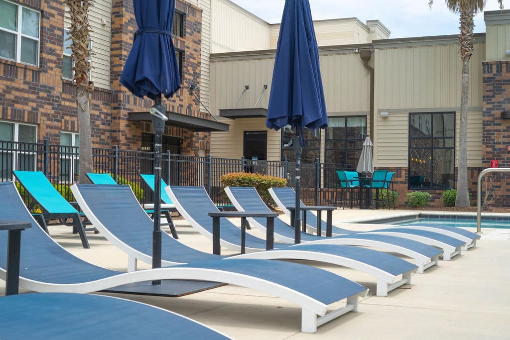 a pool with chairs and umbrellas